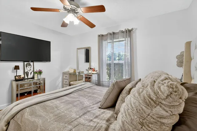 a view of swimming pool with lawn chairs and plants