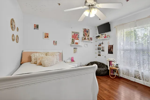 a view of a white house with a swimming pool and lawn chairs under an umbrella