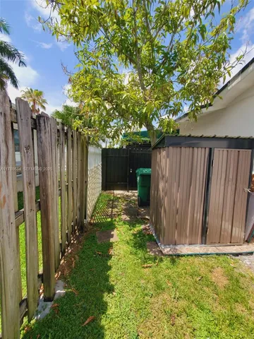 a view of a backyard with potted plants and wooden fence