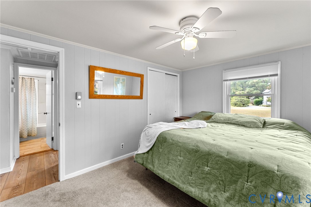 1061 Timberneck Road Deltaville, VA 23043 - Photo 18 of 28 a bedroom with a bed and a chandelier