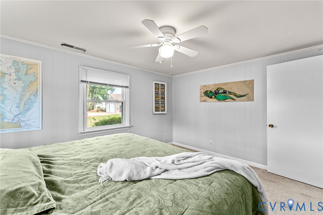 1061 Timberneck Road Deltaville, VA 23043 - Photo 20 of 28 a bedroom with a bed and a chandelier