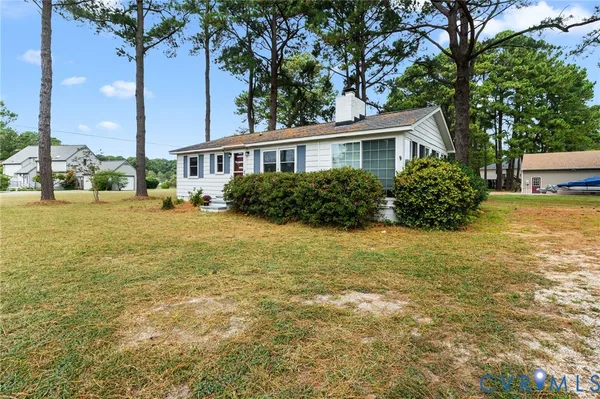 a front view of a house with a yard and potted plants
