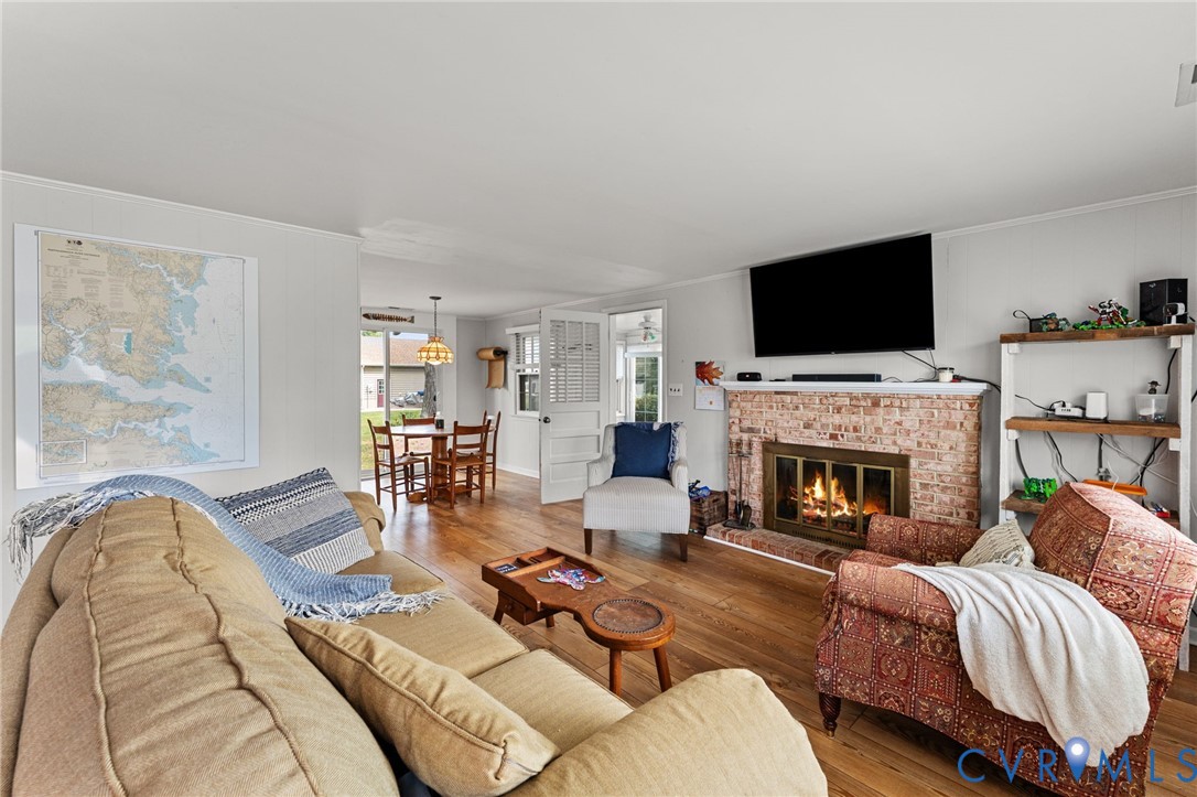 1061 Timberneck Road Deltaville, VA 23043 - Photo 4 of 28 a living room with furniture a flat screen tv and a fireplace