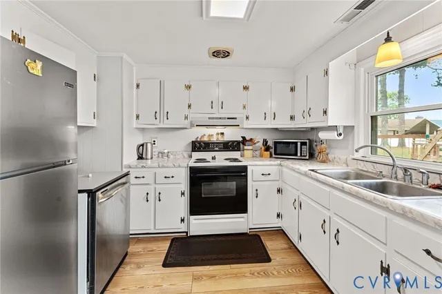 a kitchen with granite countertop a sink stainless steel appliances and cabinets