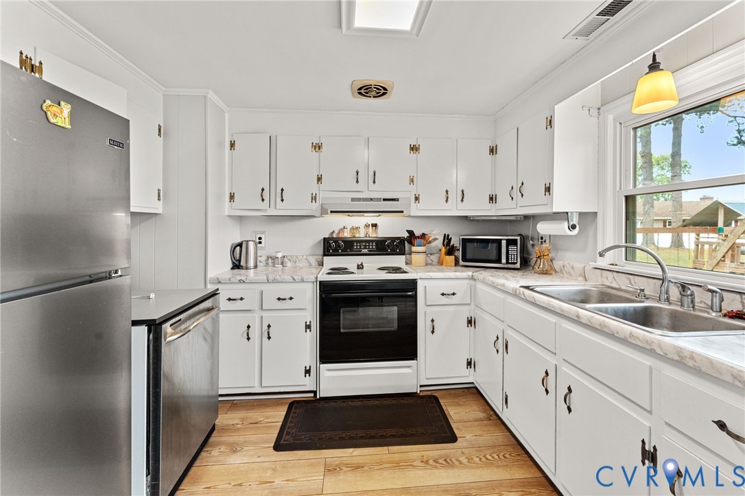 1061 Timberneck Road Deltaville, VA 23043 - Photo 10 of 28 a kitchen with granite countertop a sink stainless steel appliances and cabinets