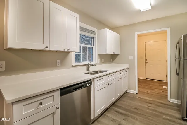 a kitchen with granite countertop white cabinets and white appliances