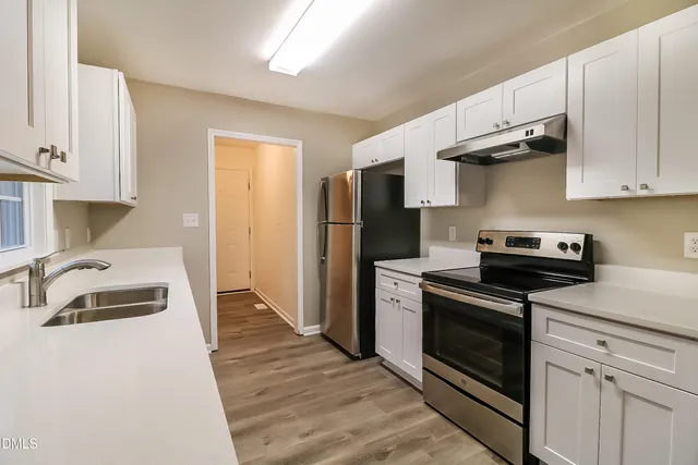 a kitchen with granite countertop a sink stove and refrigerator