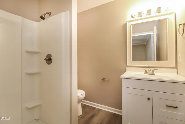a bathroom with a sink a toilet and shower