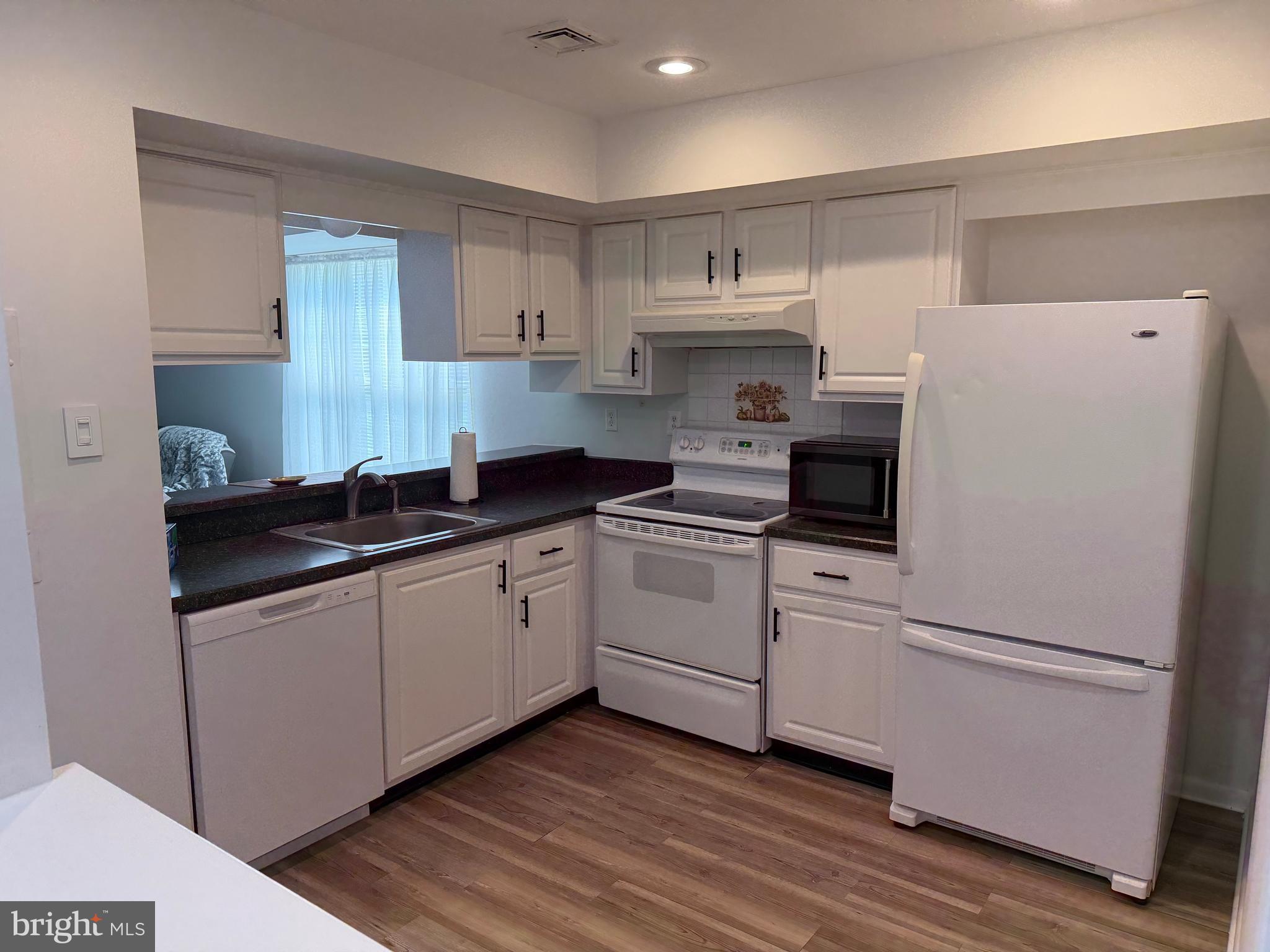 106 Pinewood Drive Hamilton, NJ 08690 - Photo 4 of 12 a kitchen with white cabinets and white appliances