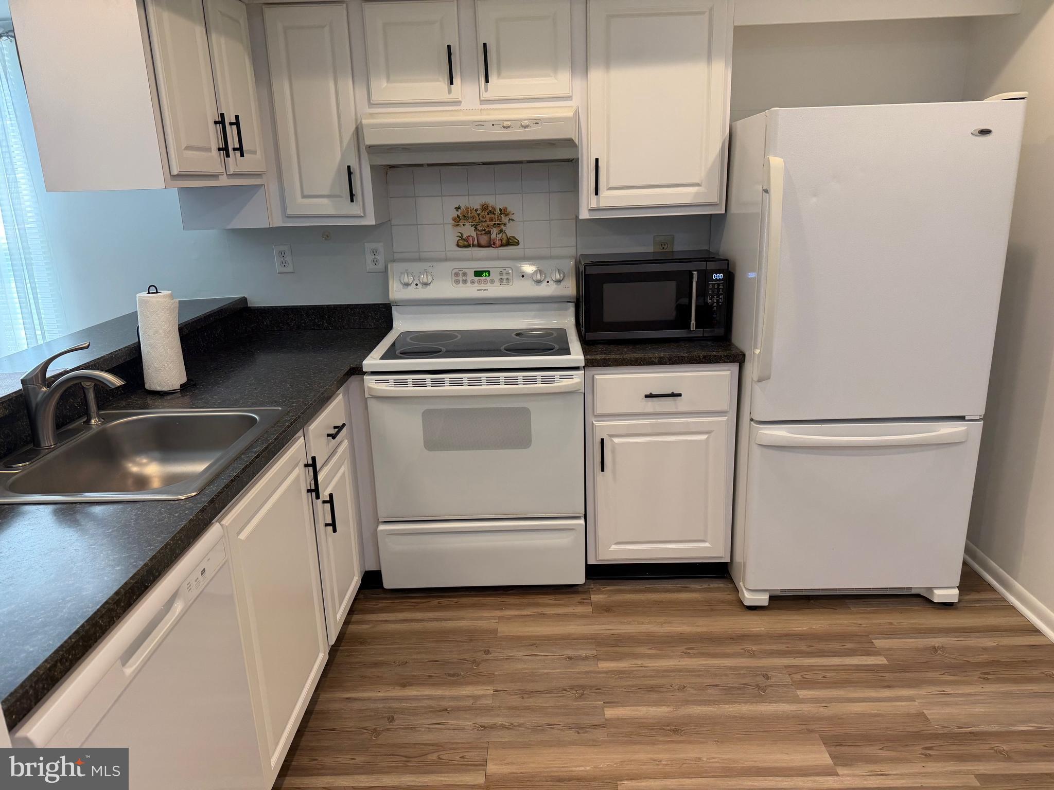 106 Pinewood Drive Hamilton, NJ 08690 - Photo 5 of 12 a kitchen with a white cabinets and white appliances