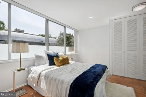 a bedroom with a large bed and a large window