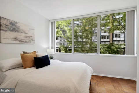 a bed sitting in a bedroom next to a window