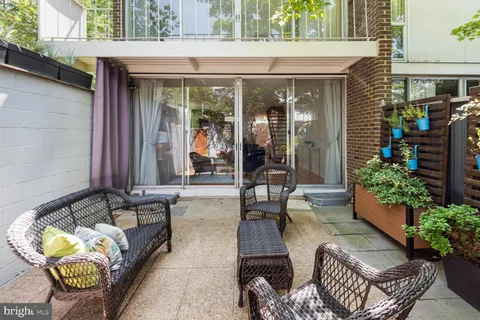 a view of a patio with couches table and chairs and potted plants
