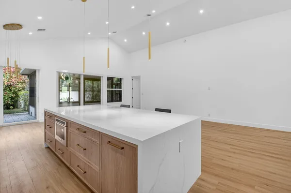 a large kitchen with kitchen island a sink table and chairs