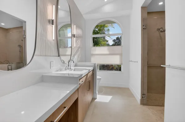 a bathroom with a tub sink vanity and mirror