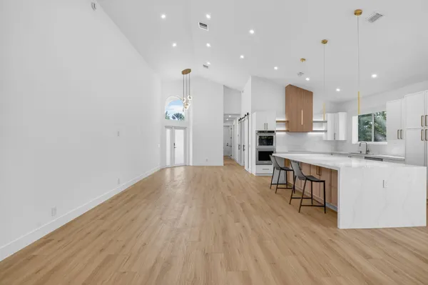 a kitchen with stainless steel appliances granite countertop a refrigerator a sink and a stove