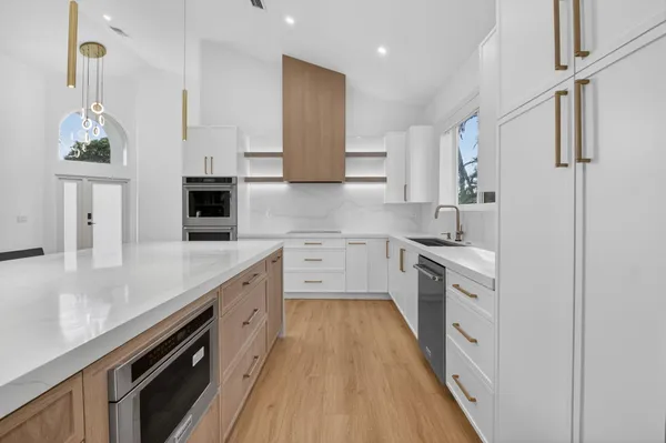 a kitchen with stainless steel appliances white cabinets and a refrigerator