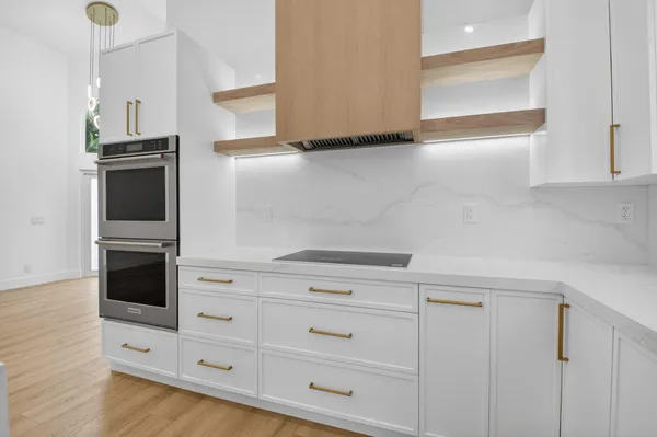 a kitchen with granite countertop white cabinets and white appliances