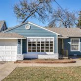 a front view of a house with a yard and potted plants