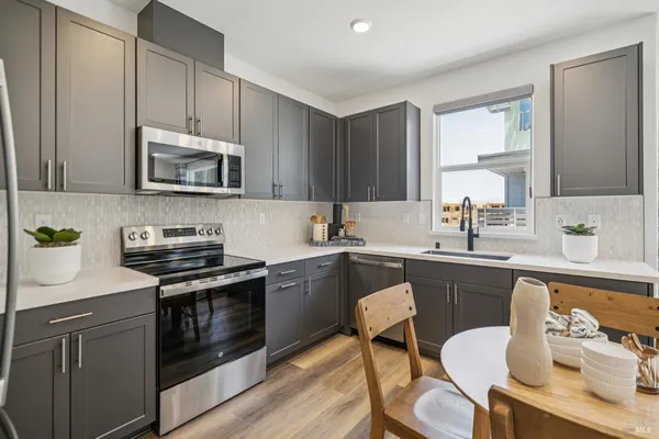 a kitchen with a stove a sink and wooden cabinets