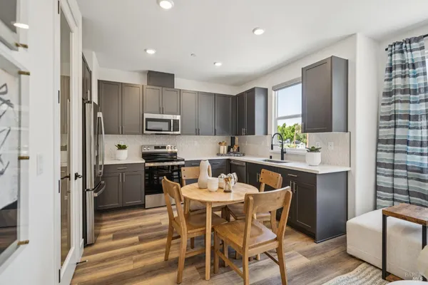 a kitchen with a table chairs microwave and refrigerator