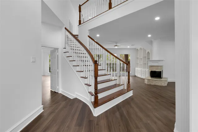 an empty room with wooden floor and staircase