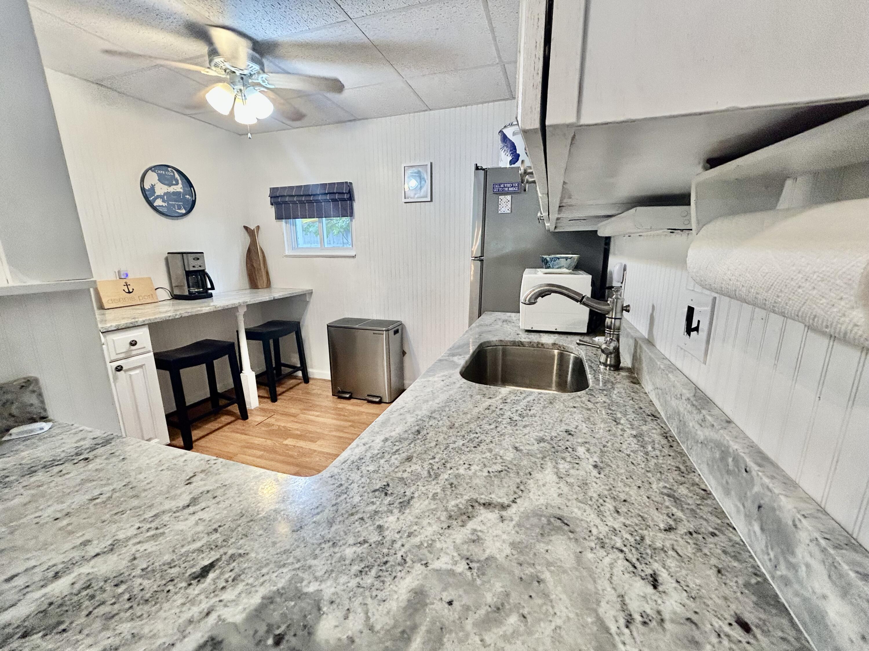 262 Old Wharf Road, Unit U67 Dennis Port, MA 02639 - Photo 20 of 54 a kitchen with stainless steel appliances kitchen island granite countertop a sink a stove top oven a chimney and a refrigerator