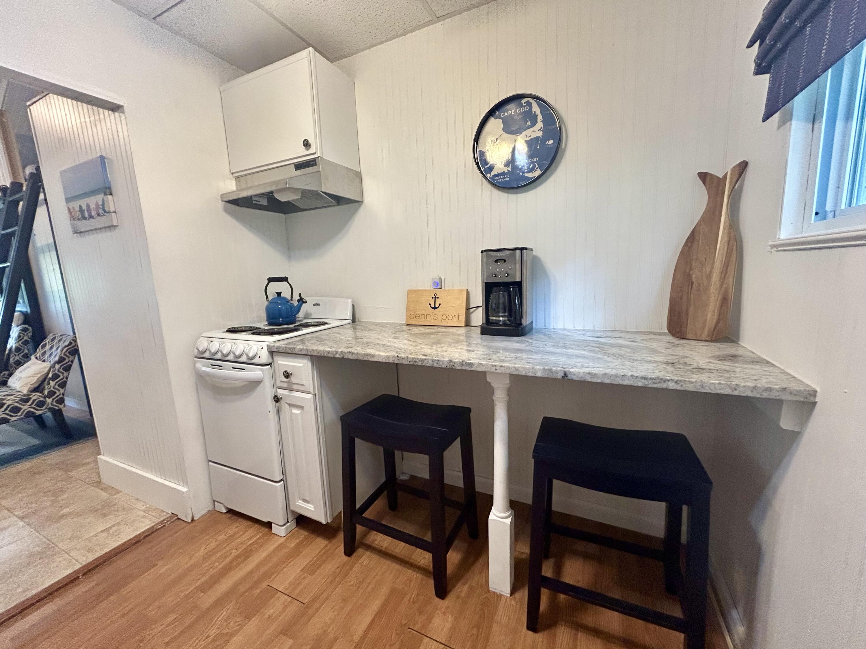 262 Old Wharf Road, Unit U67 Dennis Port, MA 02639 - Photo 25 of 54 a kitchen with stainless steel appliances granite countertop a stove a sink dishwasher and a refrigerator with wooden floor