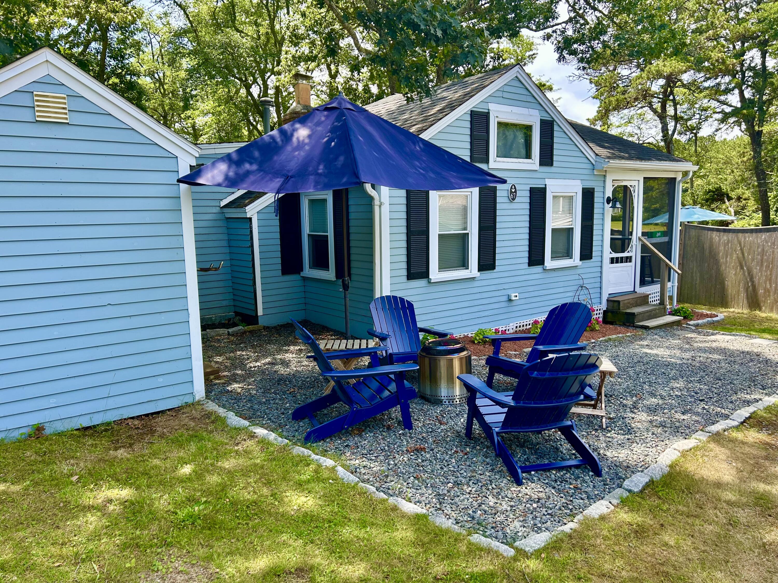 262 Old Wharf Road, Unit U67 Dennis Port, MA 02639 - Photo 51 of 54 a view of a house with a yard chairs and table in the patio