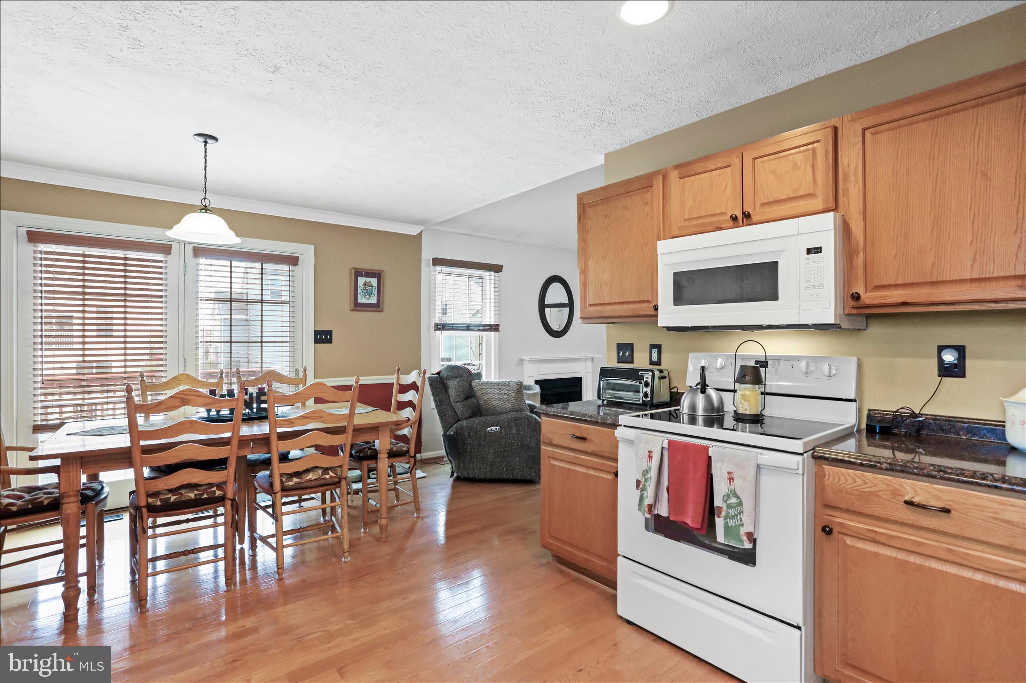 107 Briar Run Drive Ranson, WV 25438 - Photo 15 of 45 a open kitchen with granite countertop a stove a sink a dining table and chairs