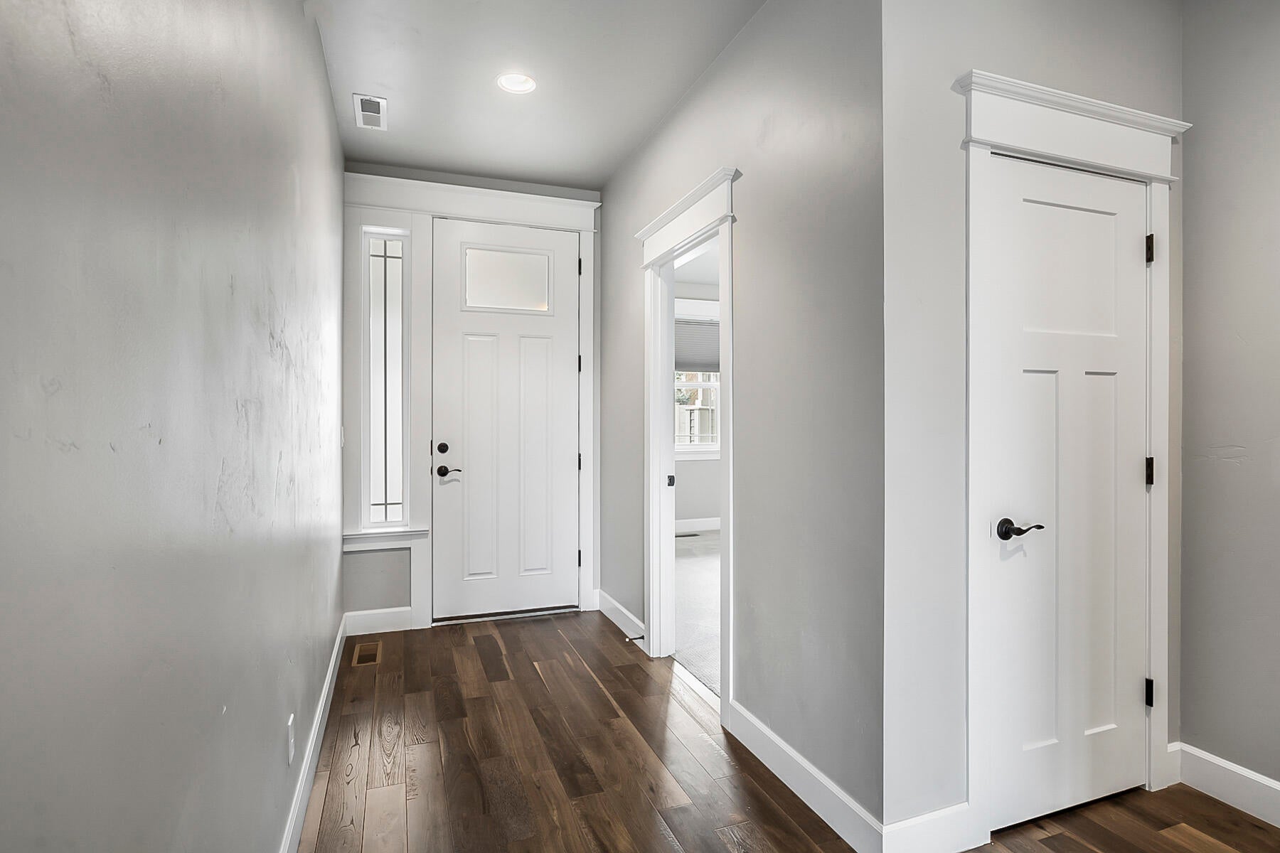 From the front entry, hardwood floors guide you into the foyer with access to Guest Bedroom 1, a coat closet and
