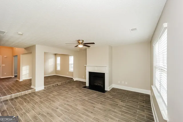 wooden floor fireplace and windows in an empty room