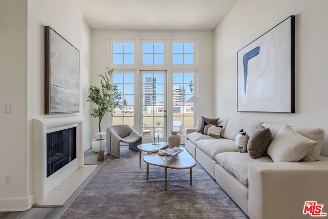 a living room with furniture a fireplace and a large window