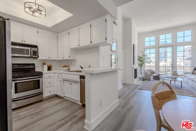 a kitchen with stainless steel appliances granite countertop a stove and white cabinets