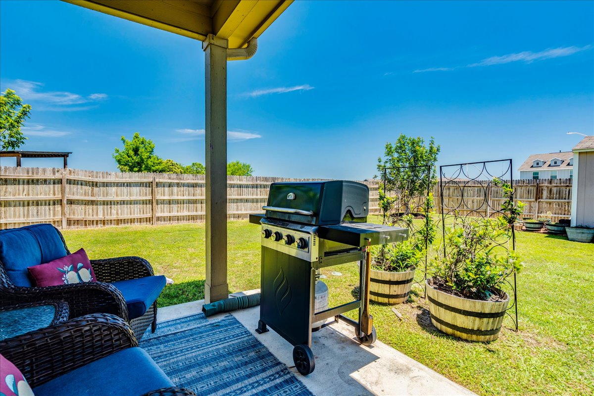 358 Jasper Trail Buda, TX 78610 - Photo 30 of 35 Covered patio with concrete flooring, extending to a manicured lawn