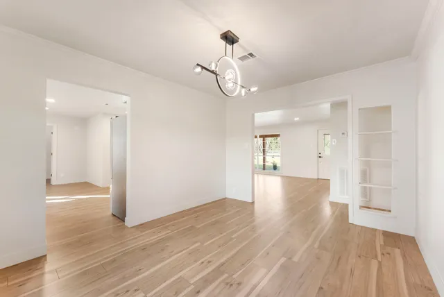 a view of a livingroom with a chandelier fan and windows