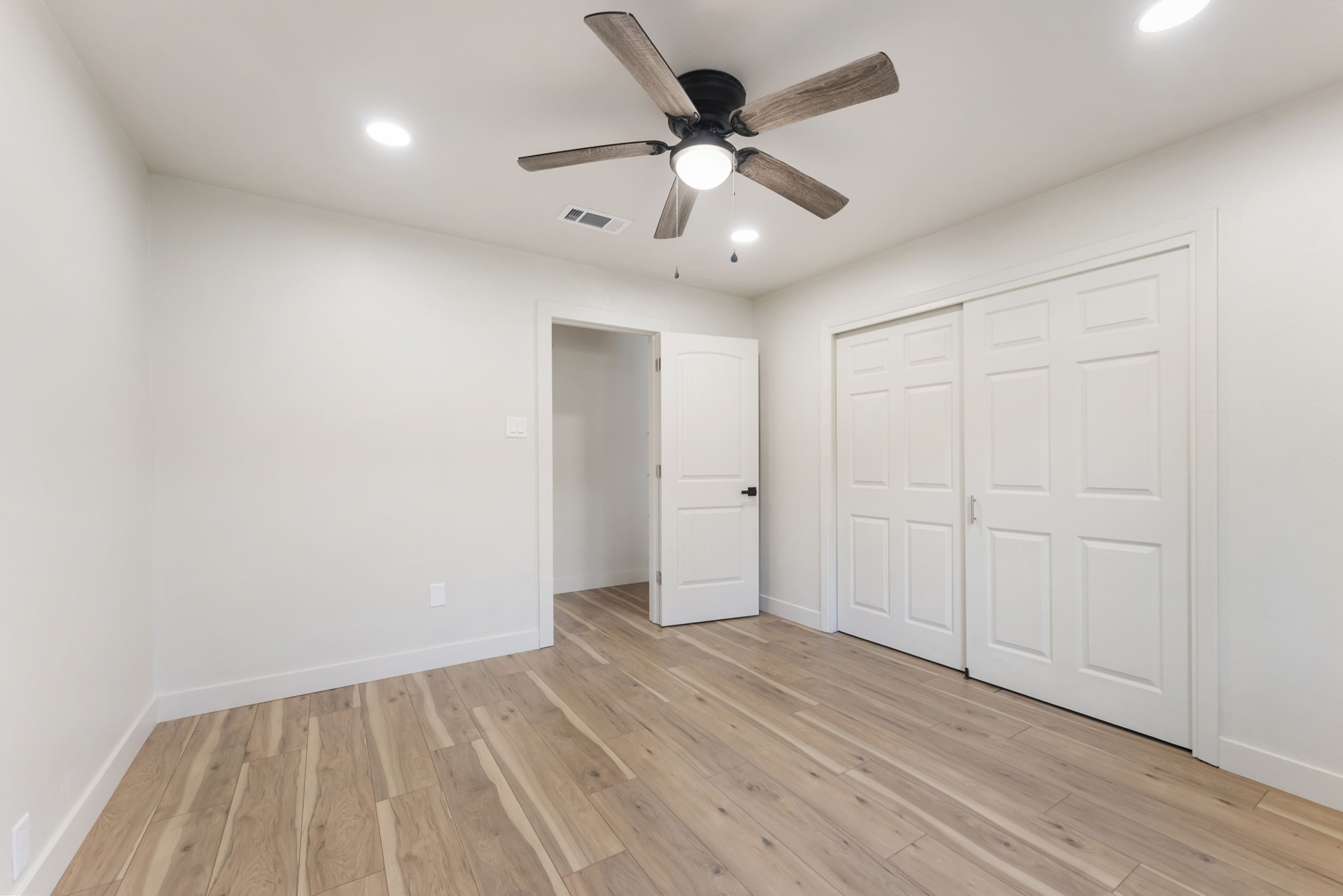 24521 Magnolia Road Hockley, TX 77447 - Photo 13 of 50 an empty room with wooden floor and a ceiling fan