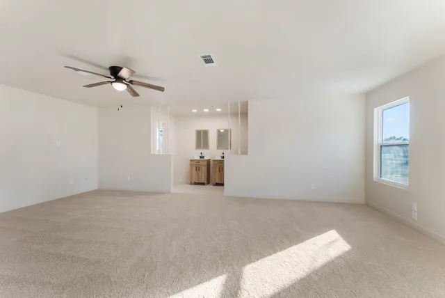 an empty room with a window and a ceiling fan