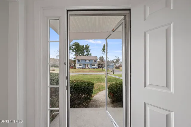 a view of a hallway with wooden floor and entryway
