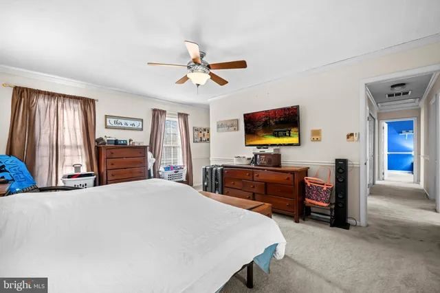 a bedroom with a bed and a flat tv screen on dresser