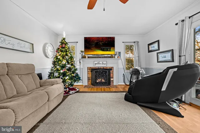 a living room with furniture a flat screen tv and a fireplace