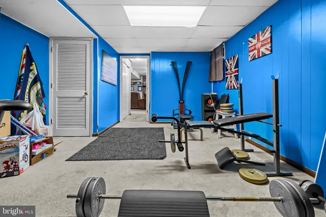 a living room with furniture gym equipment and a window