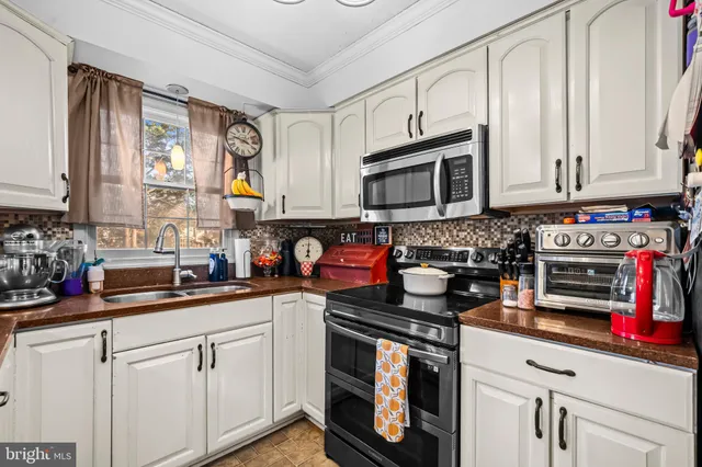 a kitchen with stainless steel appliances granite countertop a sink a stove a microwave and cabinets