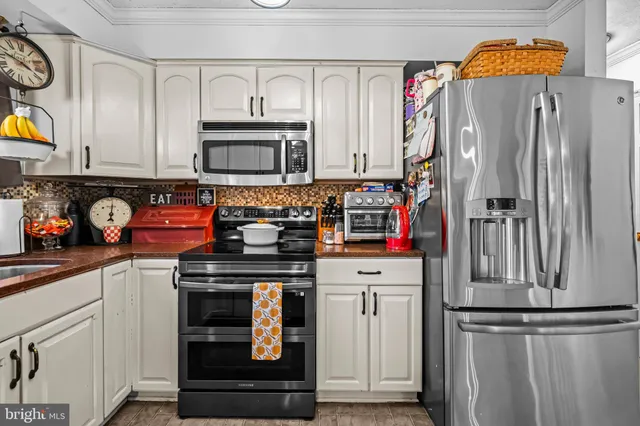 a kitchen with stainless steel appliances granite countertop a refrigerator and a stove
