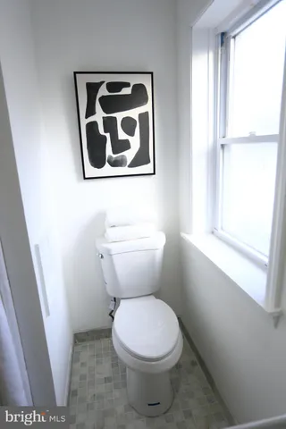 a white toilet sitting next to a window