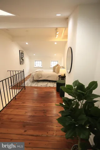 a bedroom with bed and wooden floor