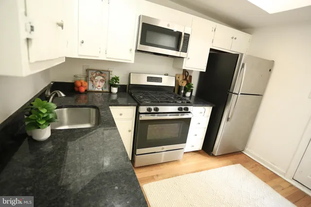a kitchen with stainless steel appliances a stove refrigerator and microwave