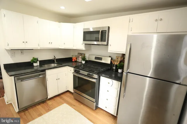 a kitchen with a refrigerator stove and white cabinets