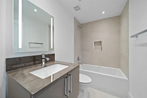 a bathroom with a sink a toilet a vanity and shower