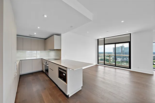 a kitchen with stainless steel appliances white cabinets and wooden floor
